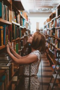 woman searching book shelves