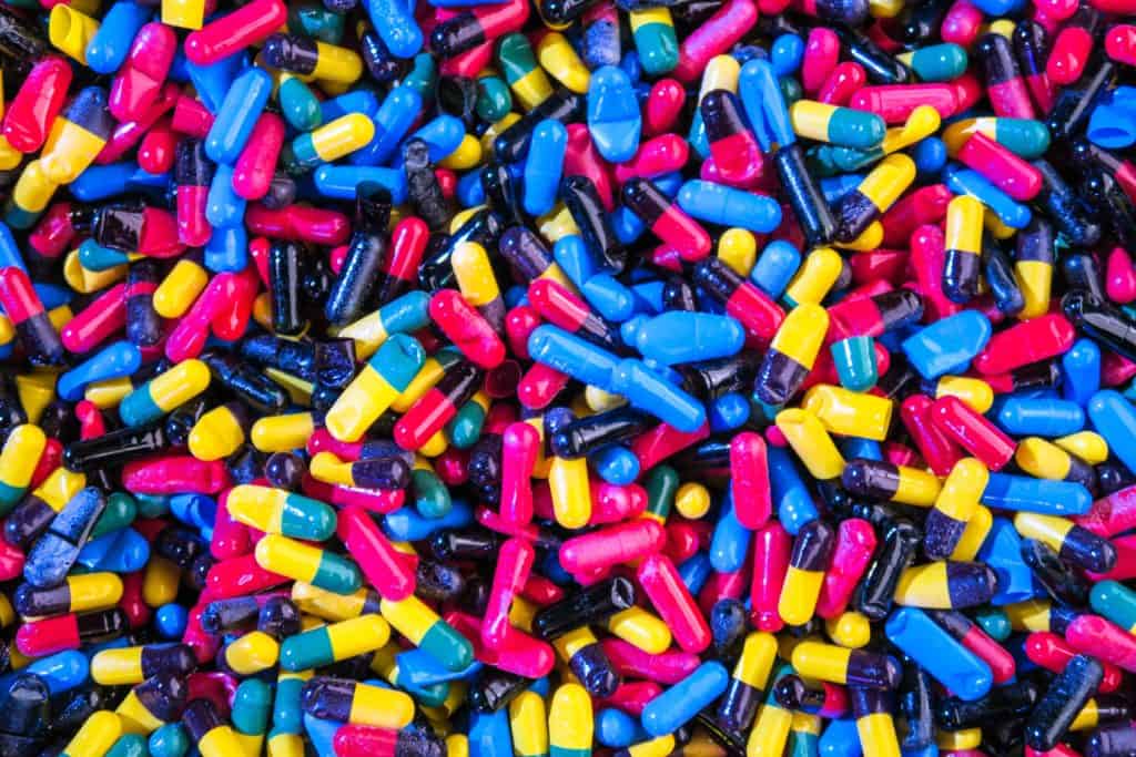 collection of multi colored pills scattered in a pile