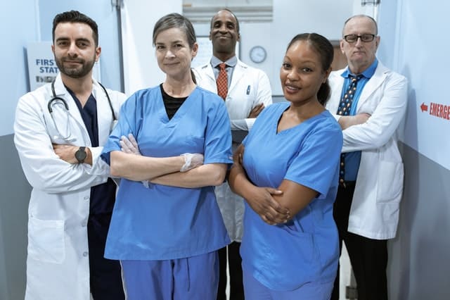 group of doctor diverse in both race and gender stand together, smiling