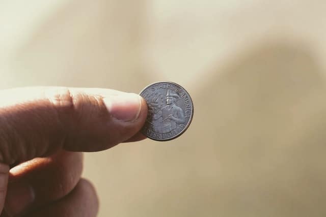 a quarter being held up between pinched fingers. 