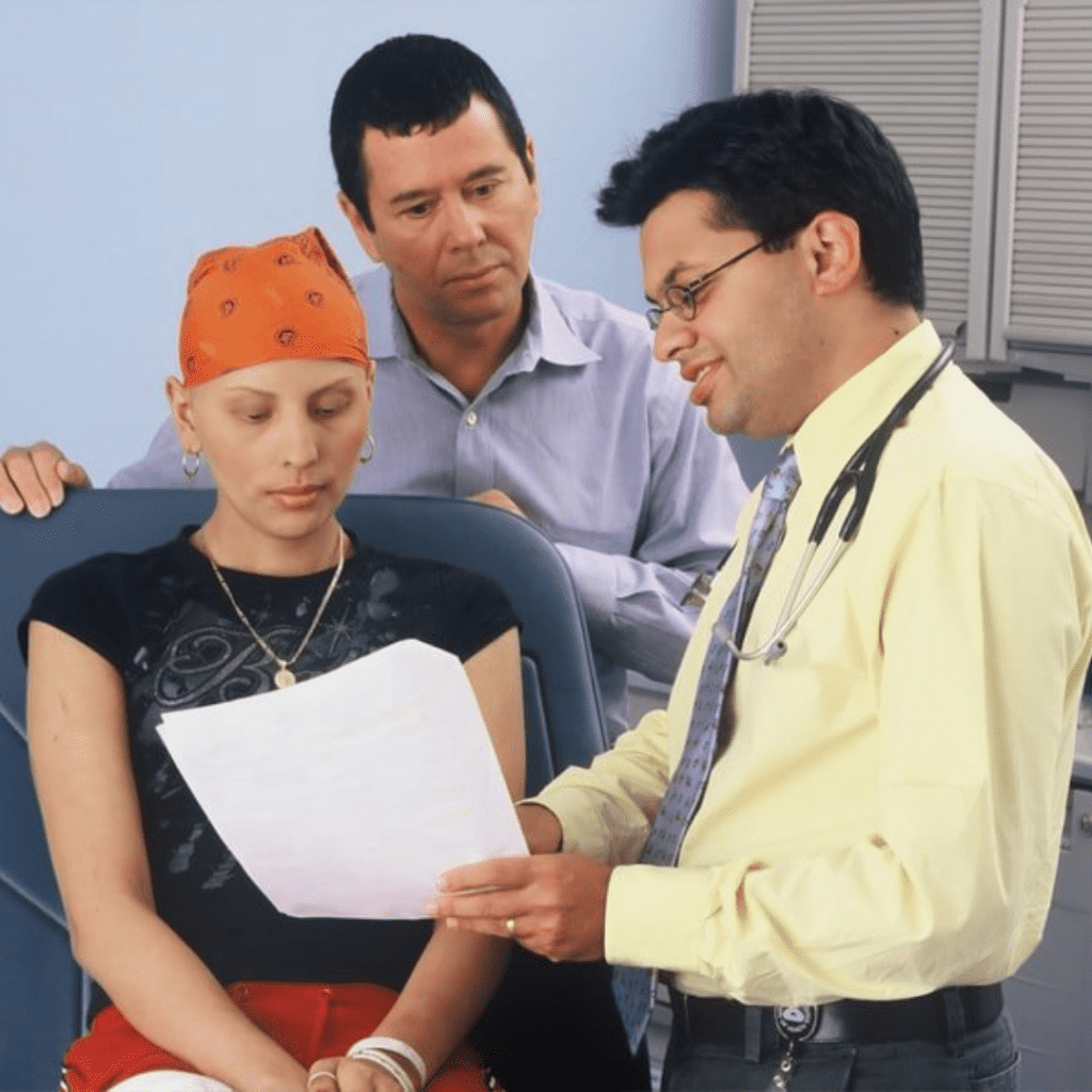 a hispanic doctor shows information to a younger female hispanic patient as a hispanic man looks over her shoulder
